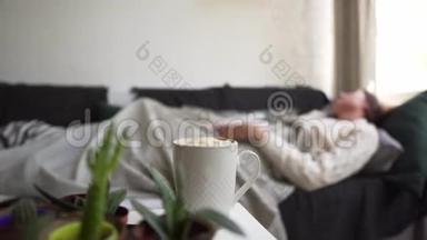 一个穿着白色毛衣的<strong>学生</strong>在沙发上<strong>睡</strong>着了，正在<strong>学习</strong>一本书。 一杯热咖啡背景下的女孩